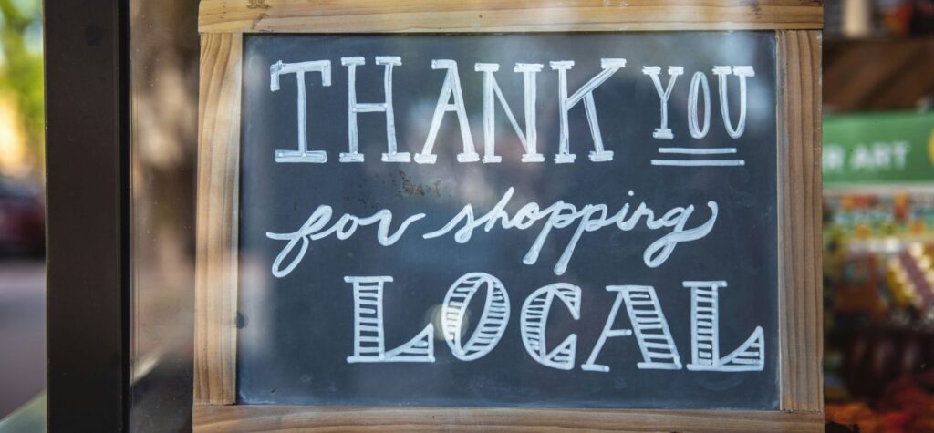 A chalkboard sign with handwritten thank you for shopping local