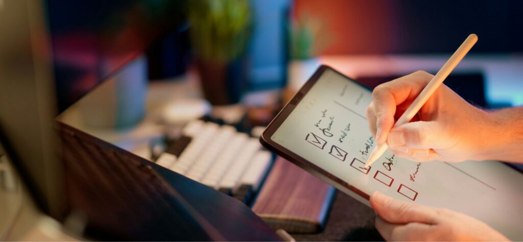 Close up of a digital artist using a stylus on a tablet, representing creative tech gifts for designers.