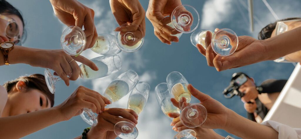 Group toasting champagne glasses looking up blue sky