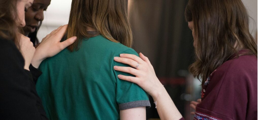 Hands supporting friend shoulders comfort group