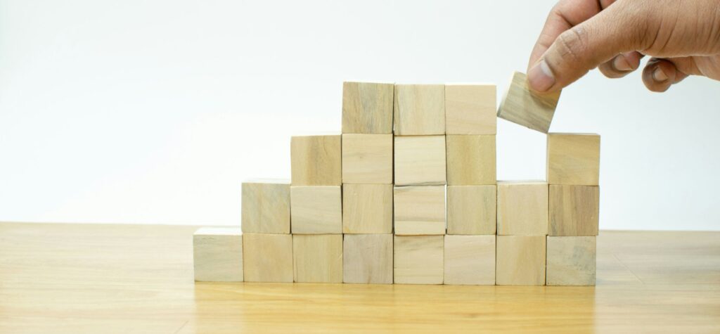 Hand stacking wooden blocks pyramid