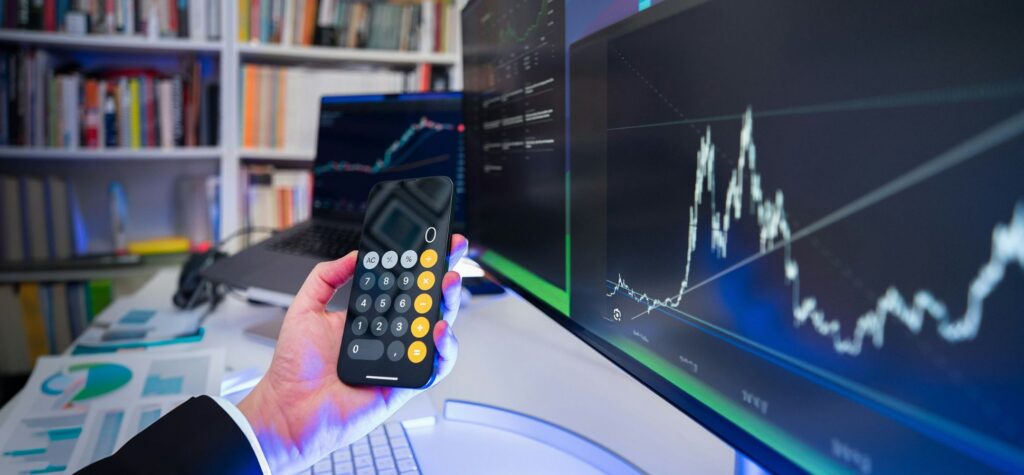 Hand with calculator financial trading