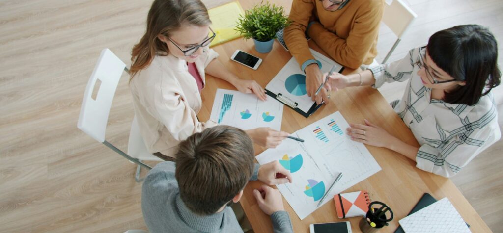 Overhead view people discussing charts