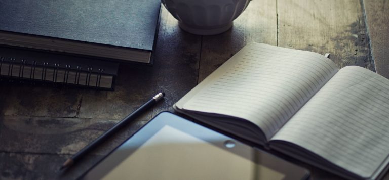 Writer's desk with notebook and tablet illustrating how much newsletters make