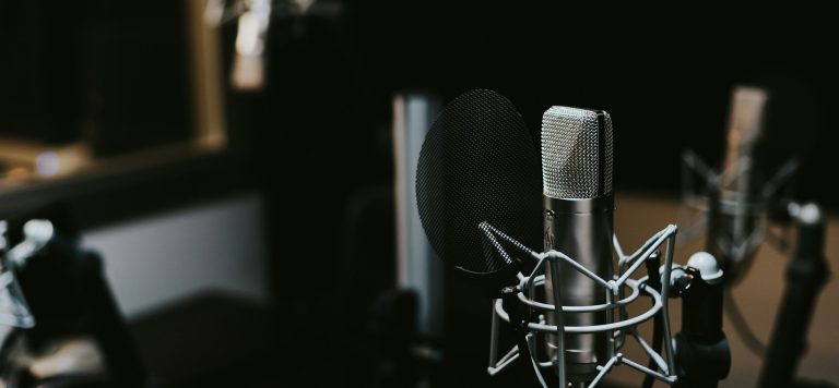 Steven Bartlett net worth 2026 represented by a podcast studio microphone