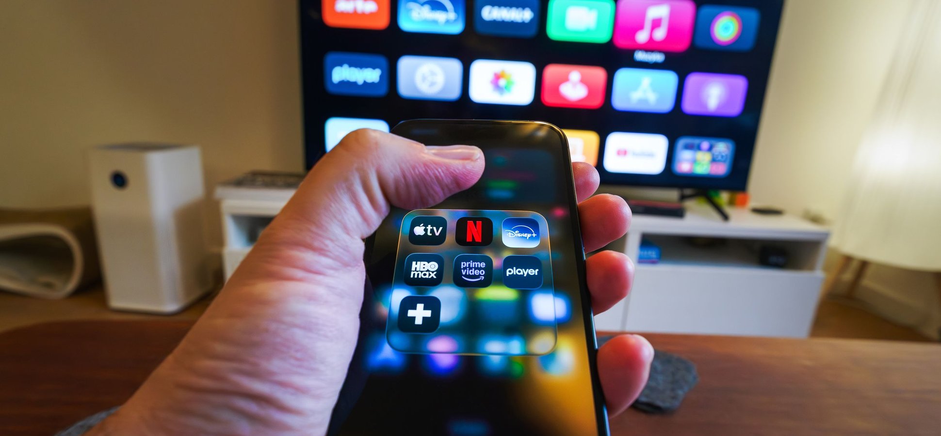 Hand holding a phone showing streaming apps, illustrating the Disney Creator Ambassador Program on TikTok and Disney+
