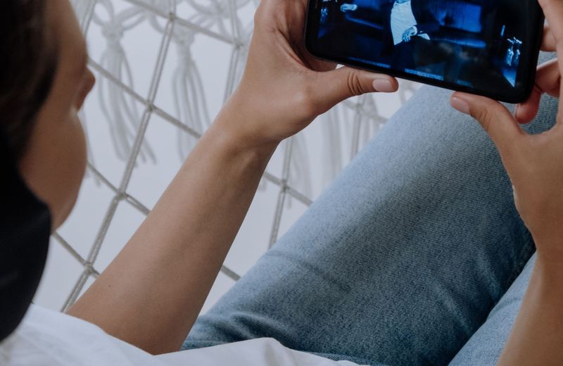 Person watching a vertical video feed on a phone, the format behind Verts on Disney+