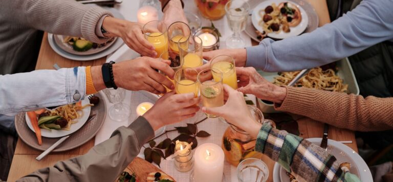 Friends toasting around a candlelit table, the loneliness economy sold as paid in-person connection