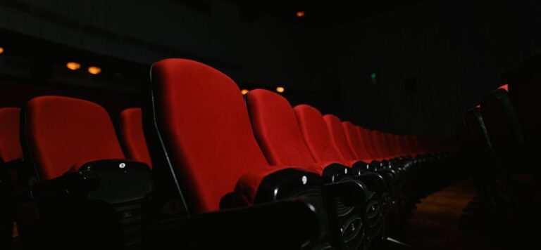 Empty red seats in a dark movie theater