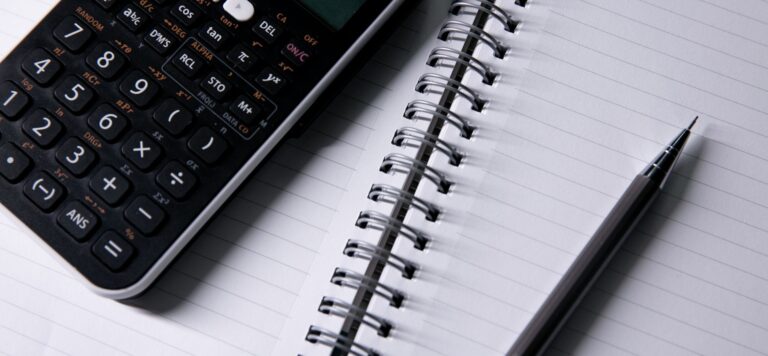 Calculator and pen on an open notebook