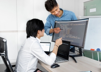 Senior and junior employees reviewing code together, should startups hire junior employees in the AI era