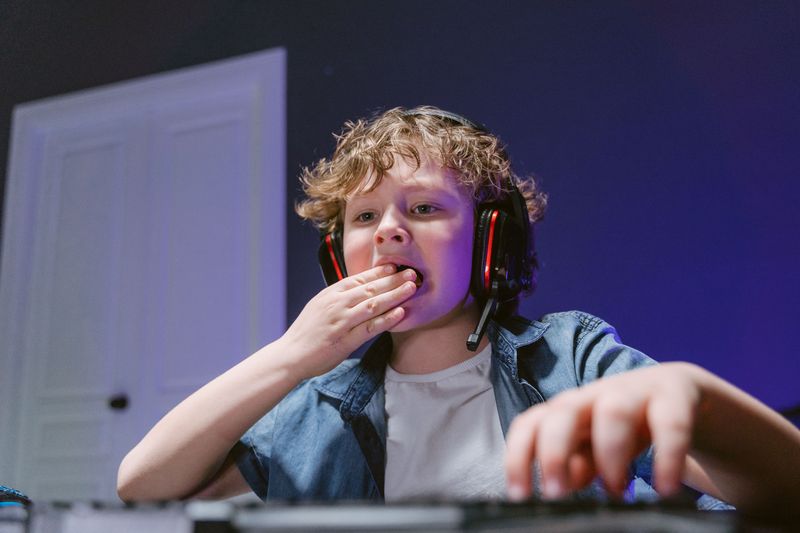 Young gamer with headphones playing at home, the audience behind Steal a Brainrot revenue and the Roblox creator economy