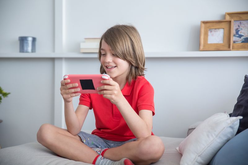 Child playing a mobile game on a tablet, the platform shift behind the Steal a Brainrot player count decline